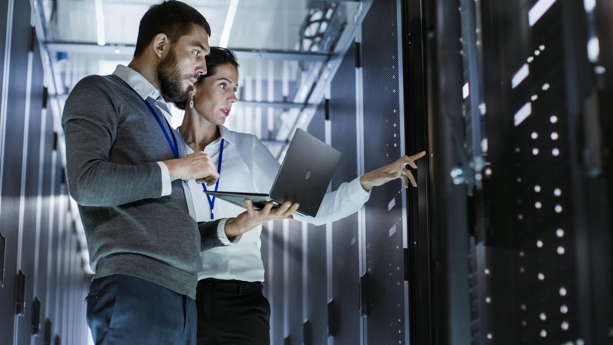 A woman and a man have a business conversation in a server room
